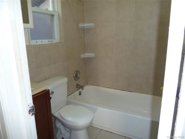 a white toilet sitting next to a bath tub