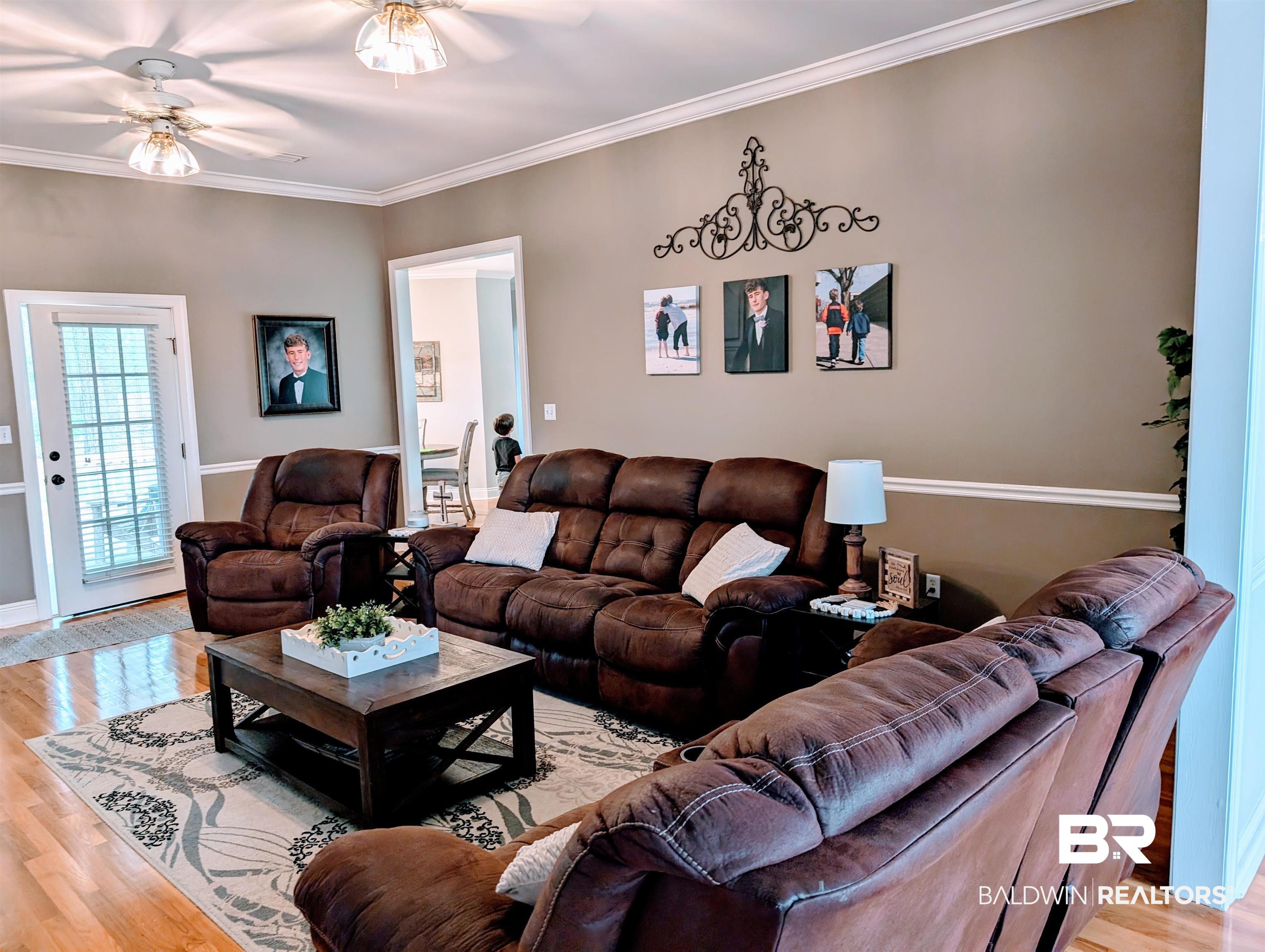 506 Old Castleberry Road Brewton, AL 36426 - Photo 5 of 14 Living room featuring ornamental molding, light wood-type flooring, and a ceiling fan