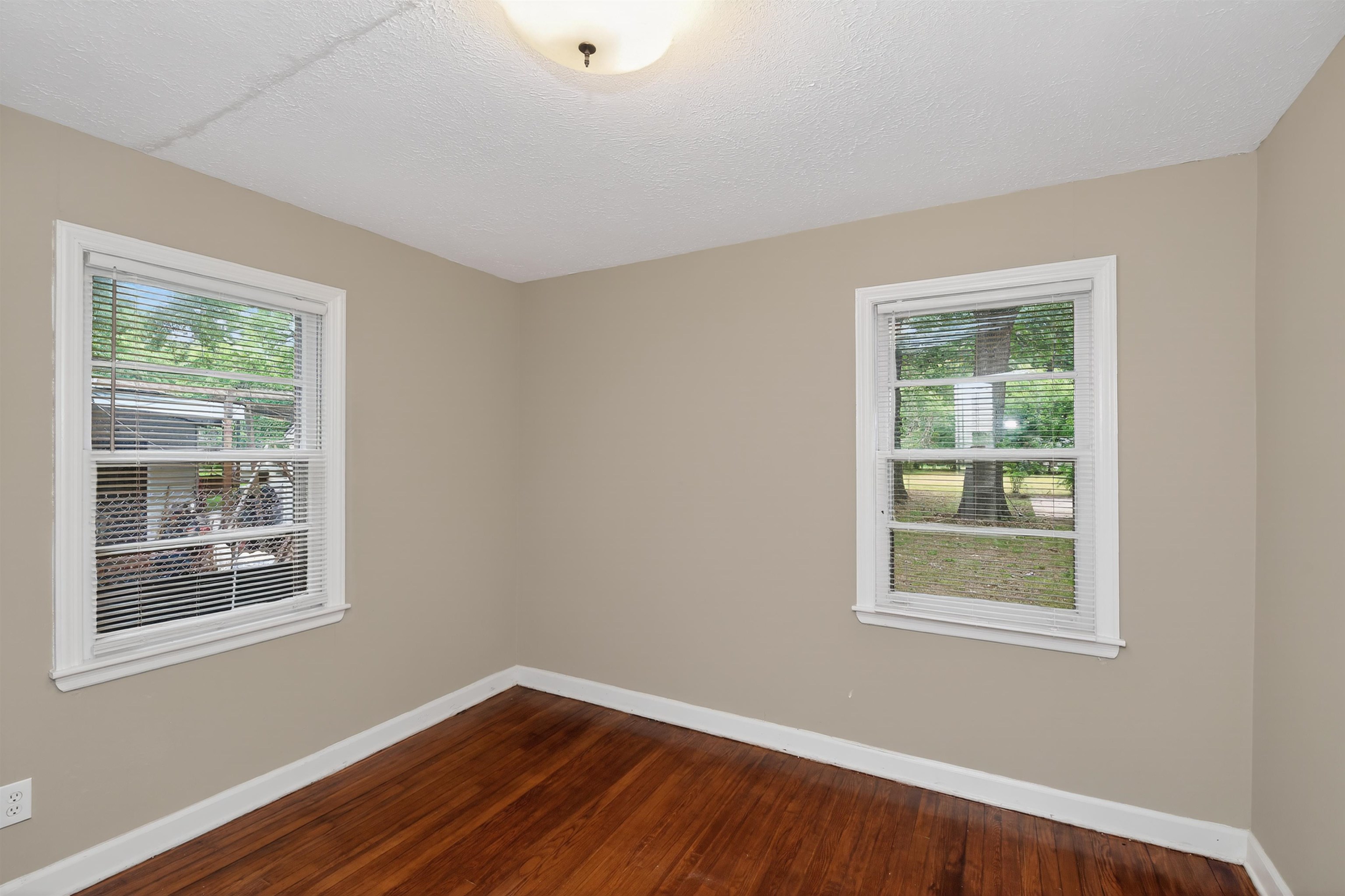 2840 Allen Road Memphis, TN 38128 - Photo 13 of 31 Interior room featuring rich wood-finish flooring, neutral-toned walls, white baseboards, and two windows with white trim