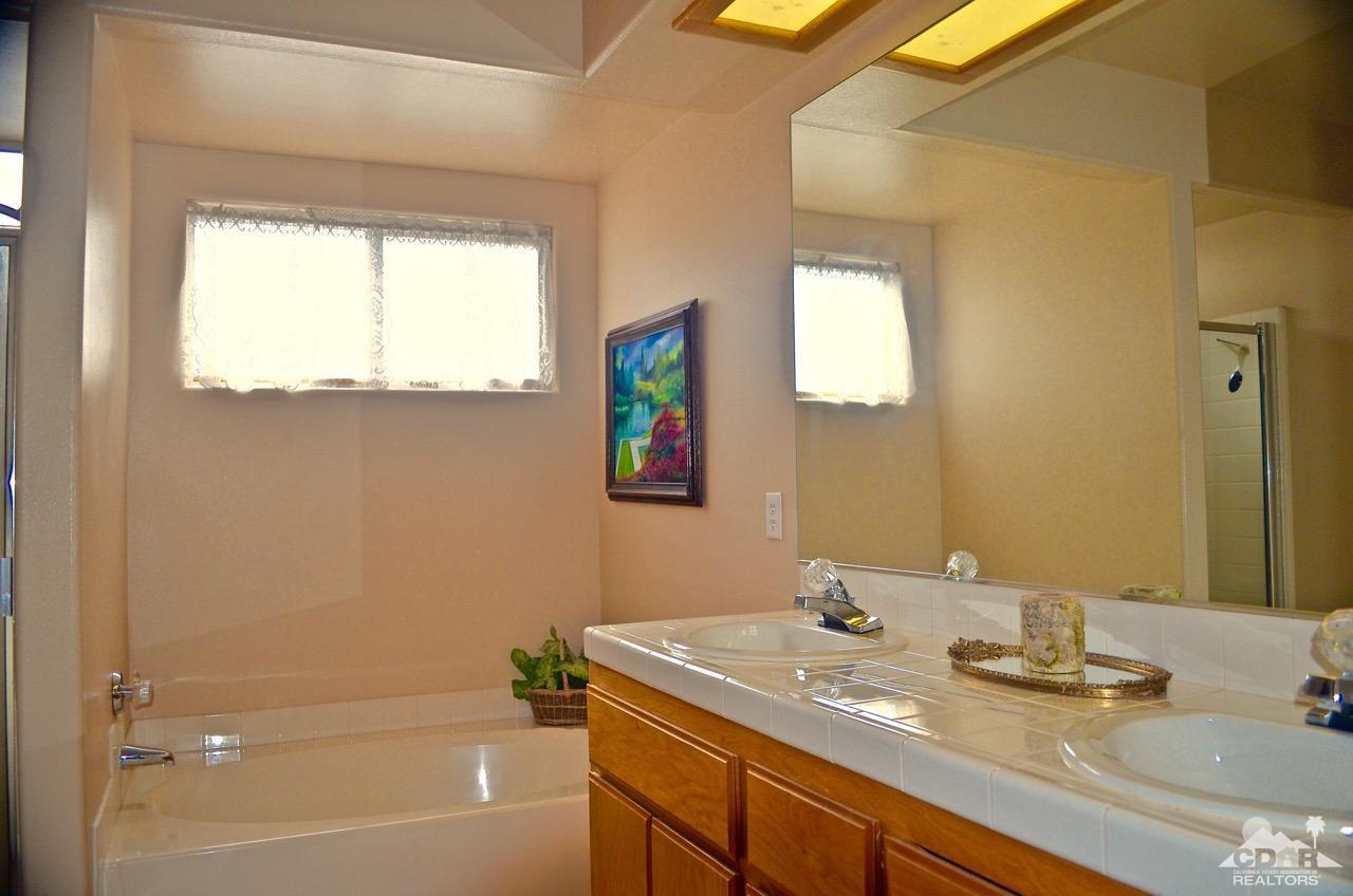68115 Durango Road Cathedral City, CA 92234 - Photo 42 of 80 a bathroom with a granite countertop sink toilet and a mirror