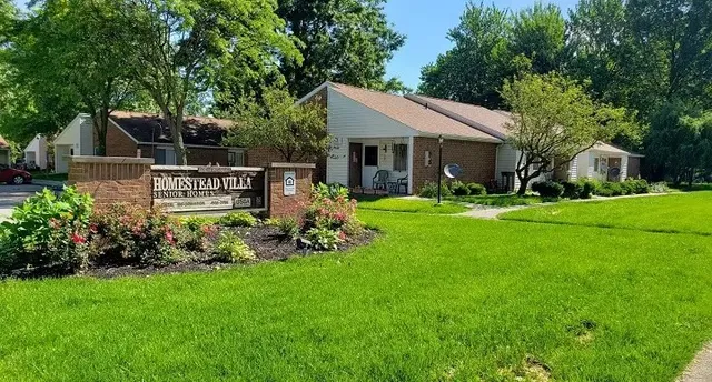 a view of a house with a yard and sitting area