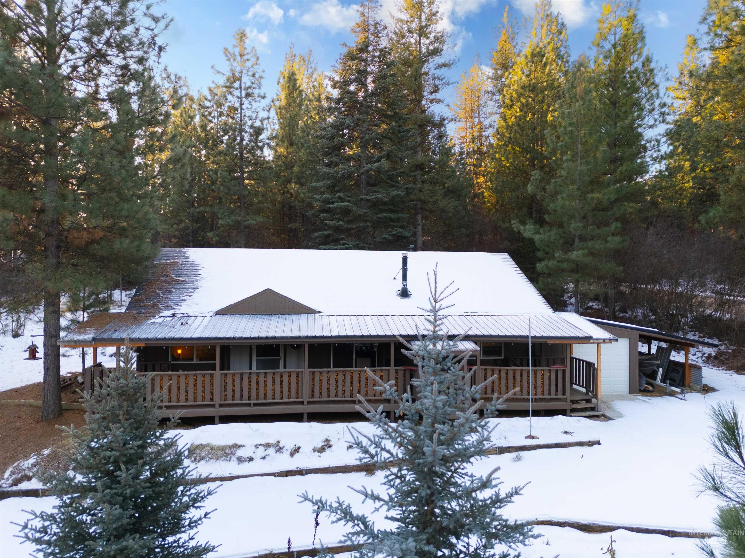 View of front of property featuring a metal roof and a porch