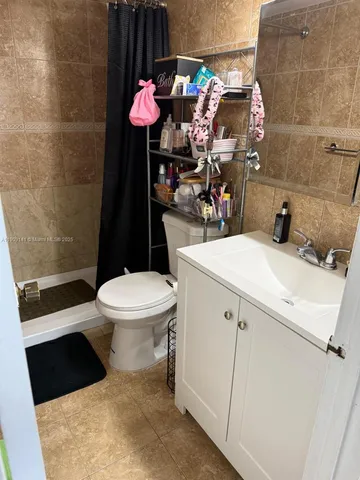 a bathroom with a granite countertop toilet sink and mirror