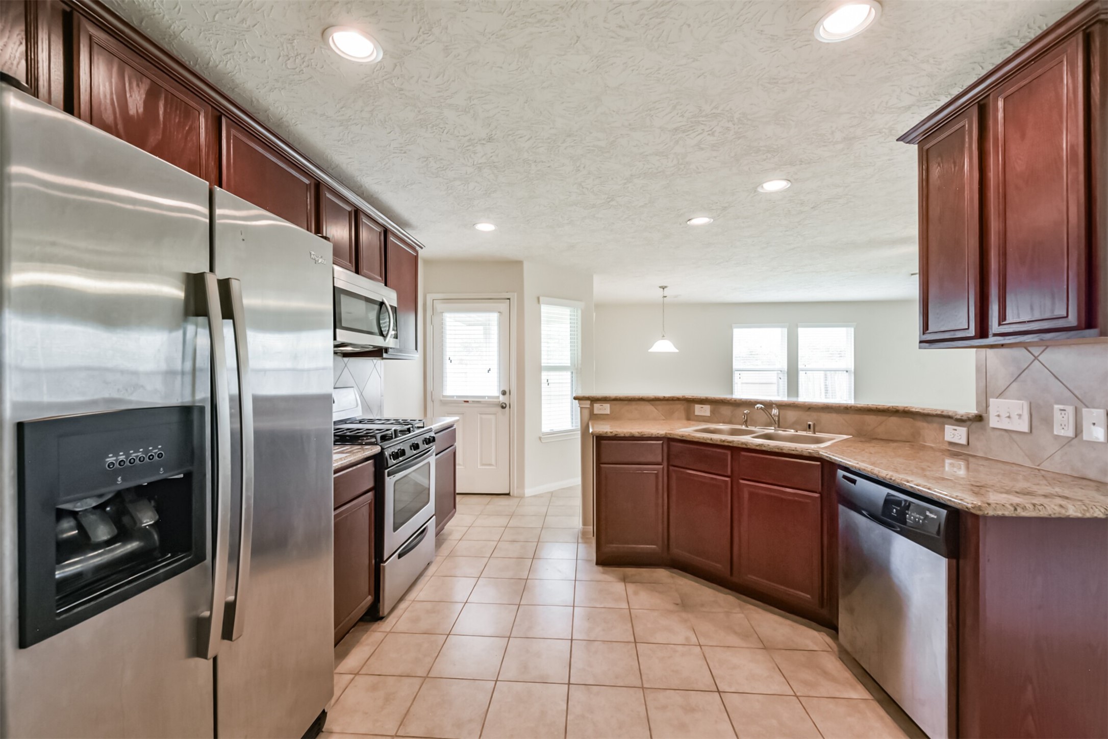 2142 Tandy Park Way Houston, TX 77047 - Photo 12 of 35 a large kitchen with stainless steel appliances granite countertop a sink and a refrigerator