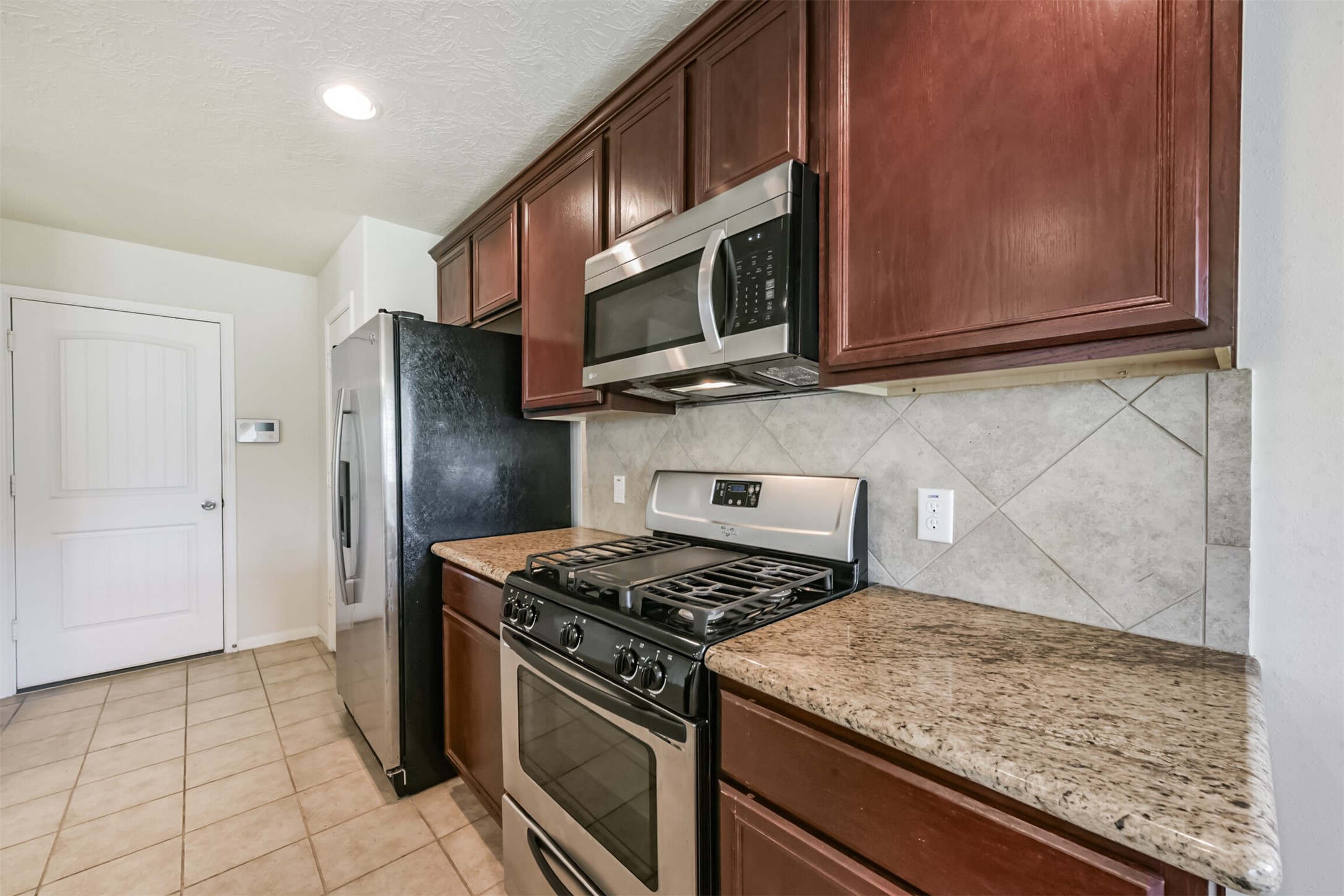 2142 Tandy Park Way Houston, TX 77047 - Photo 14 of 35 a kitchen with stainless steel appliances granite countertop a stove microwave and refrigerator