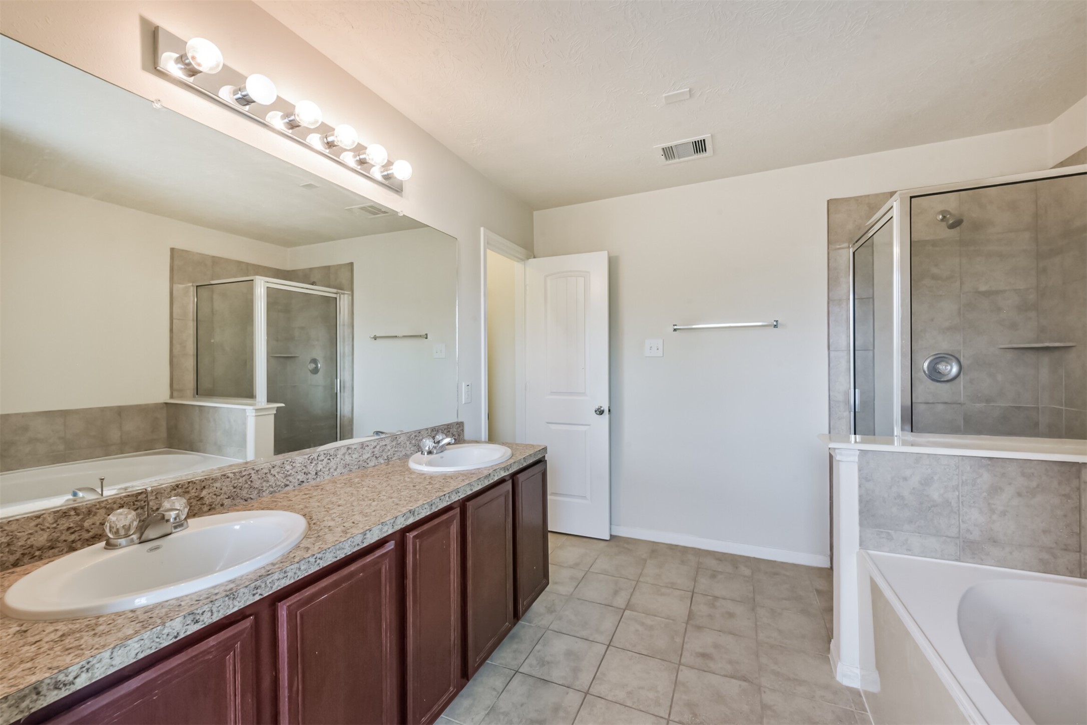 2142 Tandy Park Way Houston, TX 77047 - Photo 20 of 35 a bathroom with a granite countertop sink a large mirror and a bathtub