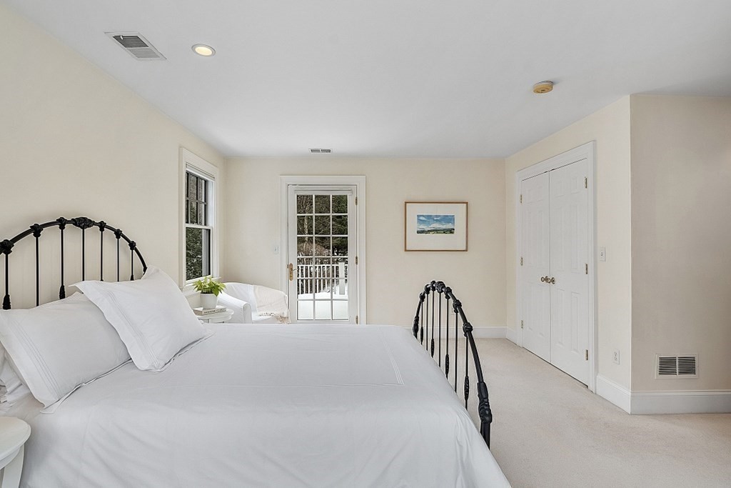 61 Garfield Road Concord, MA 01742 - Photo 24 of 33 a bedroom with a bed next to a window and a potted plant on a dresser