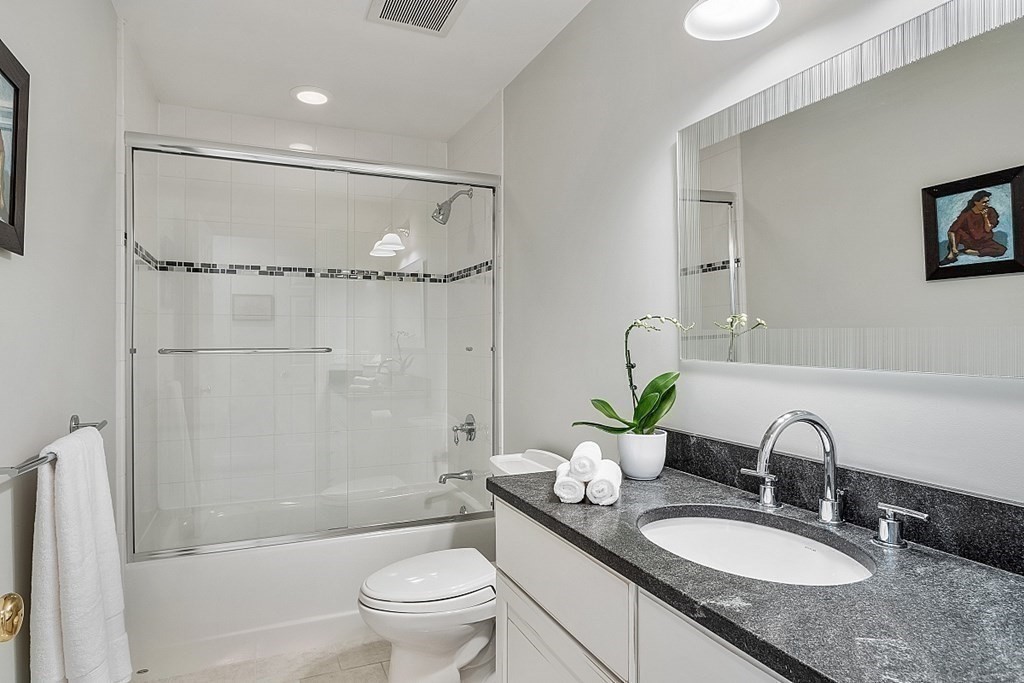 61 Garfield Road Concord, MA 01742 - Photo 25 of 33 a bathroom with a granite countertop sink toilet a shower and a mirror
