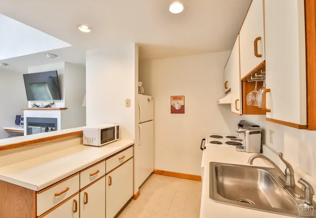 a kitchen with stainless steel appliances granite countertop a sink and a stove top oven with wooden floor