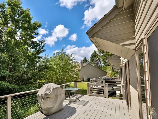 a roof deck with table and chairs and wooden floor