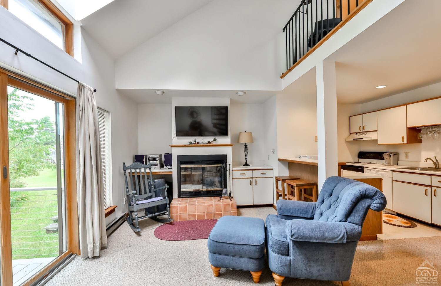 91 Windham Ridge Road, Unit 18B Windham, NY 12496 - Photo 7 of 30 a living room with furniture a fireplace and a flat screen tv