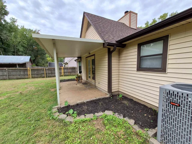 a backyard of a house with table and chairs