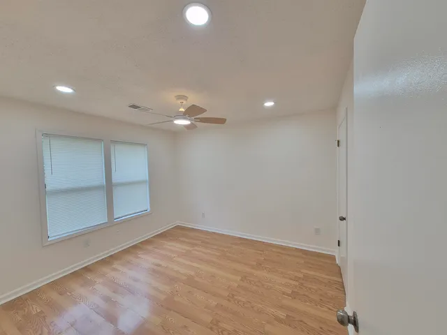 en empty room with window and ceiling fan