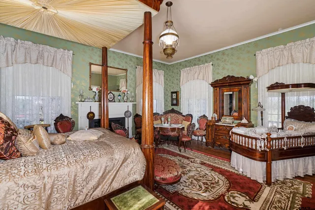 a large bedroom with bed and a large window