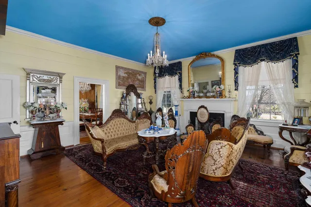a living room with fireplace furniture and a chandelier
