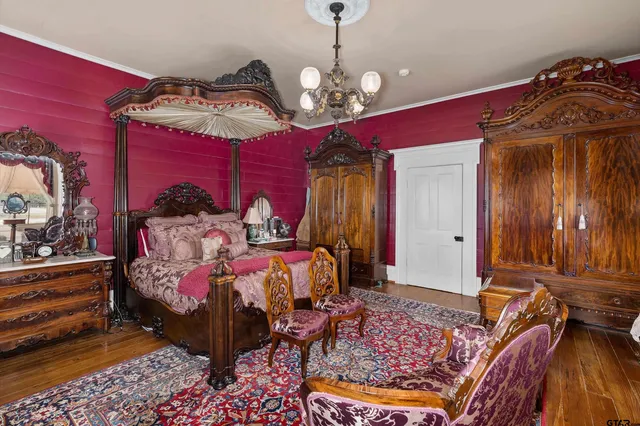 a bedroom with bed and wooden floor