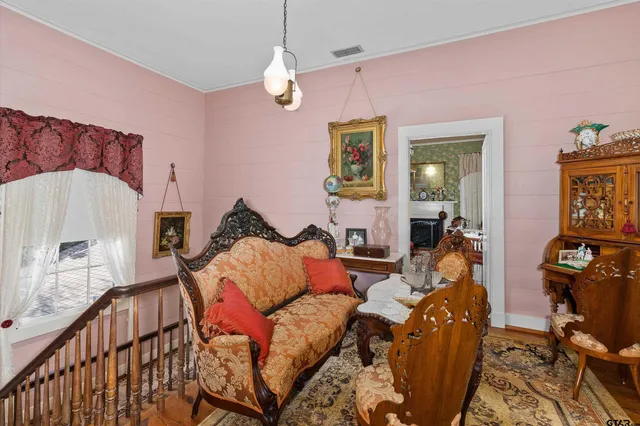 a living room with furniture a chandelier and a flat screen tv