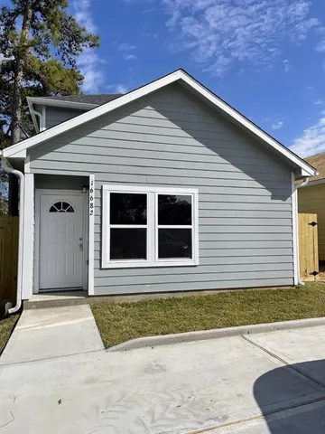 a view of a big room with wooden floor and a window