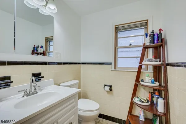 a bedroom with a bed a desk chair and windows