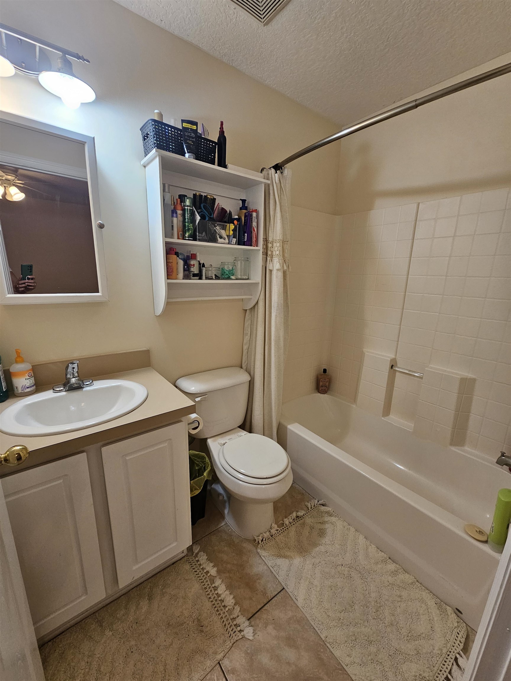 985 Cooper Street St. Augustine, FL 32084 - Photo 11 of 12 Bathroom with a textured ceiling, shower / tub combo, vanity, and light tile patterned flooring