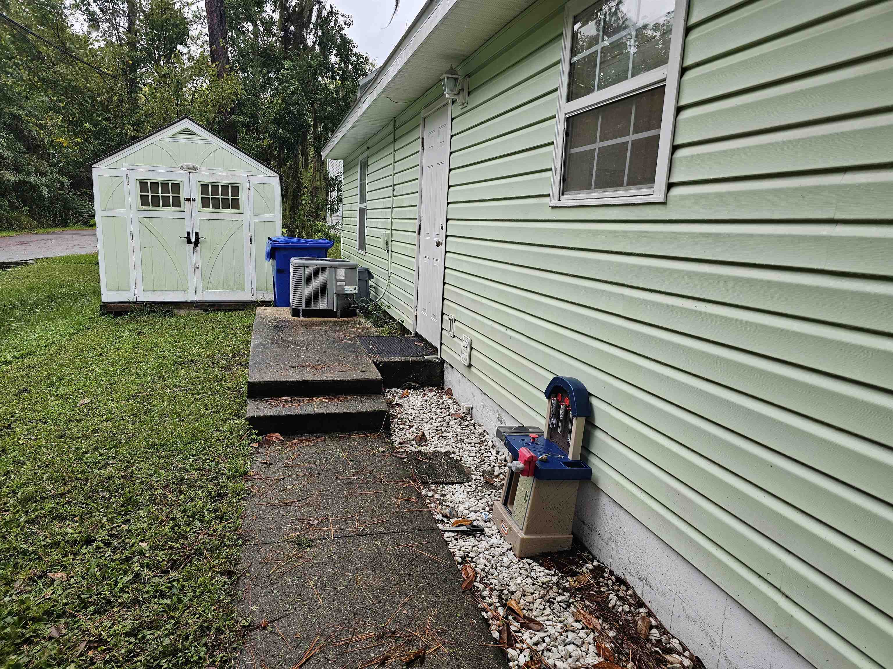 985 Cooper Street St. Augustine, FL 32084 - Photo 4 of 12 View of home's exterior with a storage unit, a yard, and a deck