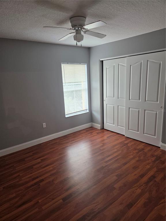 2728 Amanda Kay Way Kissimmee, FL 34744 - Photo 13 of 16 an empty room with wooden floor chandelier fan and windows
