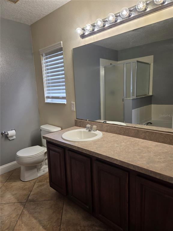 2728 Amanda Kay Way Kissimmee, FL 34744 - Photo 16 of 16 a bathroom with a granite countertop sink a toilet and a mirror
