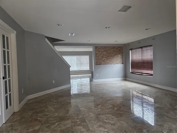 an empty room with windows and closet