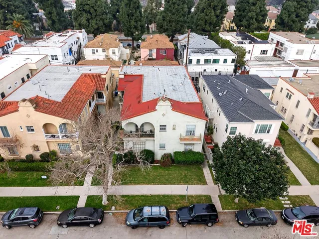 an aerial view of a houses with cars parked
