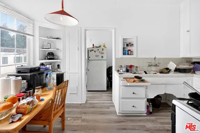 a kitchen with granite countertop a sink stove and cabinets