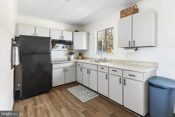 a kitchen with a sink dishwasher a refrigerator a washer and dryer with wooden cabinets