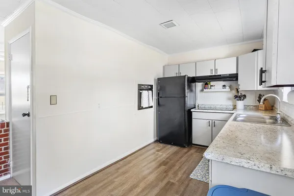 a kitchen with a refrigerator sink and wooden floor