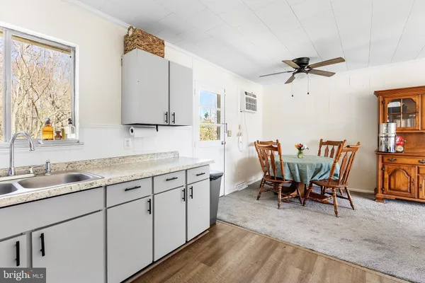 a kitchen with a dining table chairs and white appliances
