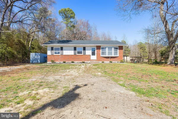 a front view of house with yard and trees around