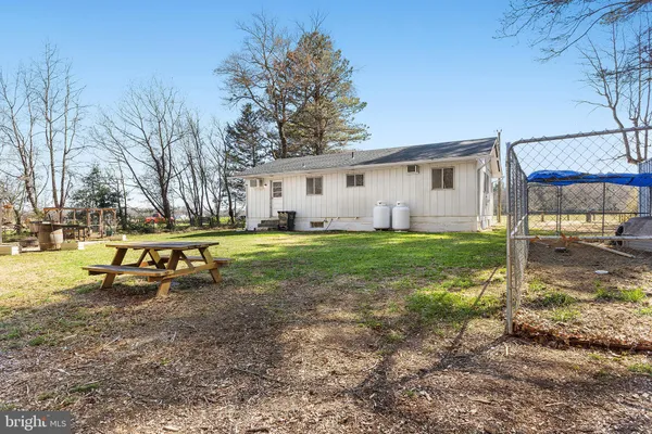 a view of a house with backyard and a tree
