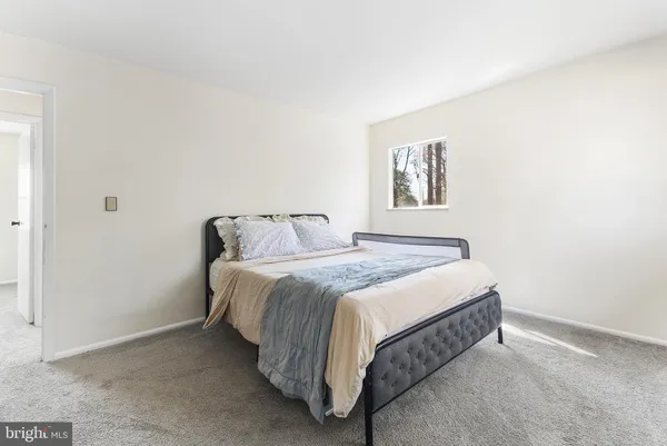 a spacious bedroom with a bed and a window