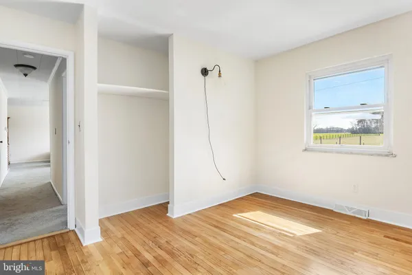 a view of empty room with wooden floor