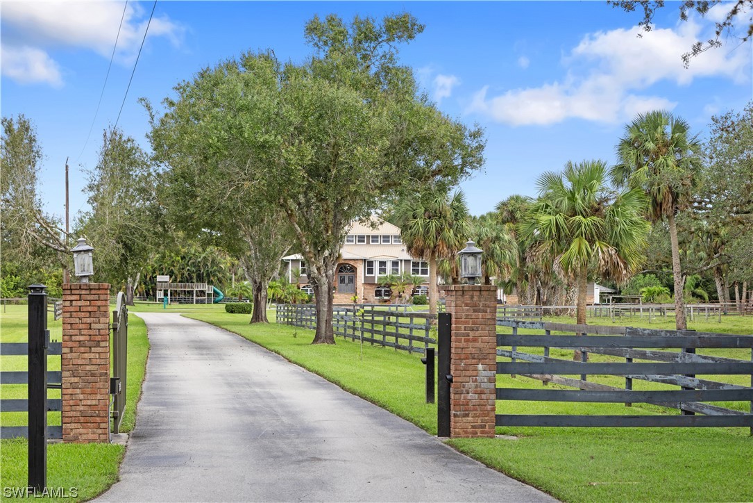 17301 Frank Road Alva, FL 33920 - Photo 3 of 46 a front view of a house with a garden and trees