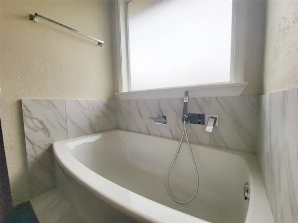 a bath tub sitting in a bathroom next to a window