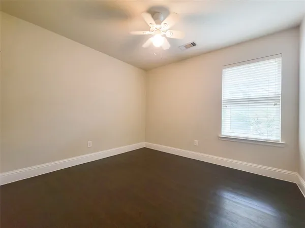 an empty room with a window and a fan