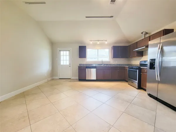 a large kitchen with cabinets and stainless steel appliances