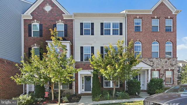 front view of a brick house with a tree in front