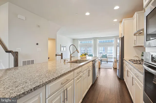 a large kitchen with kitchen island granite countertop a large counter top a sink a stove and a refrigerator