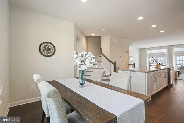 a kitchen with a table chairs and white cabinets