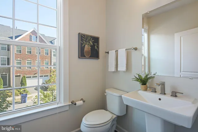 a bathroom with a toilet a sink and a large mirror