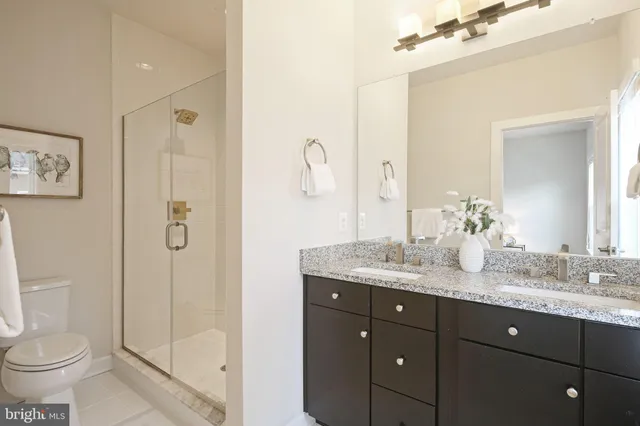 a bathroom with a granite countertop sink toilet and shower