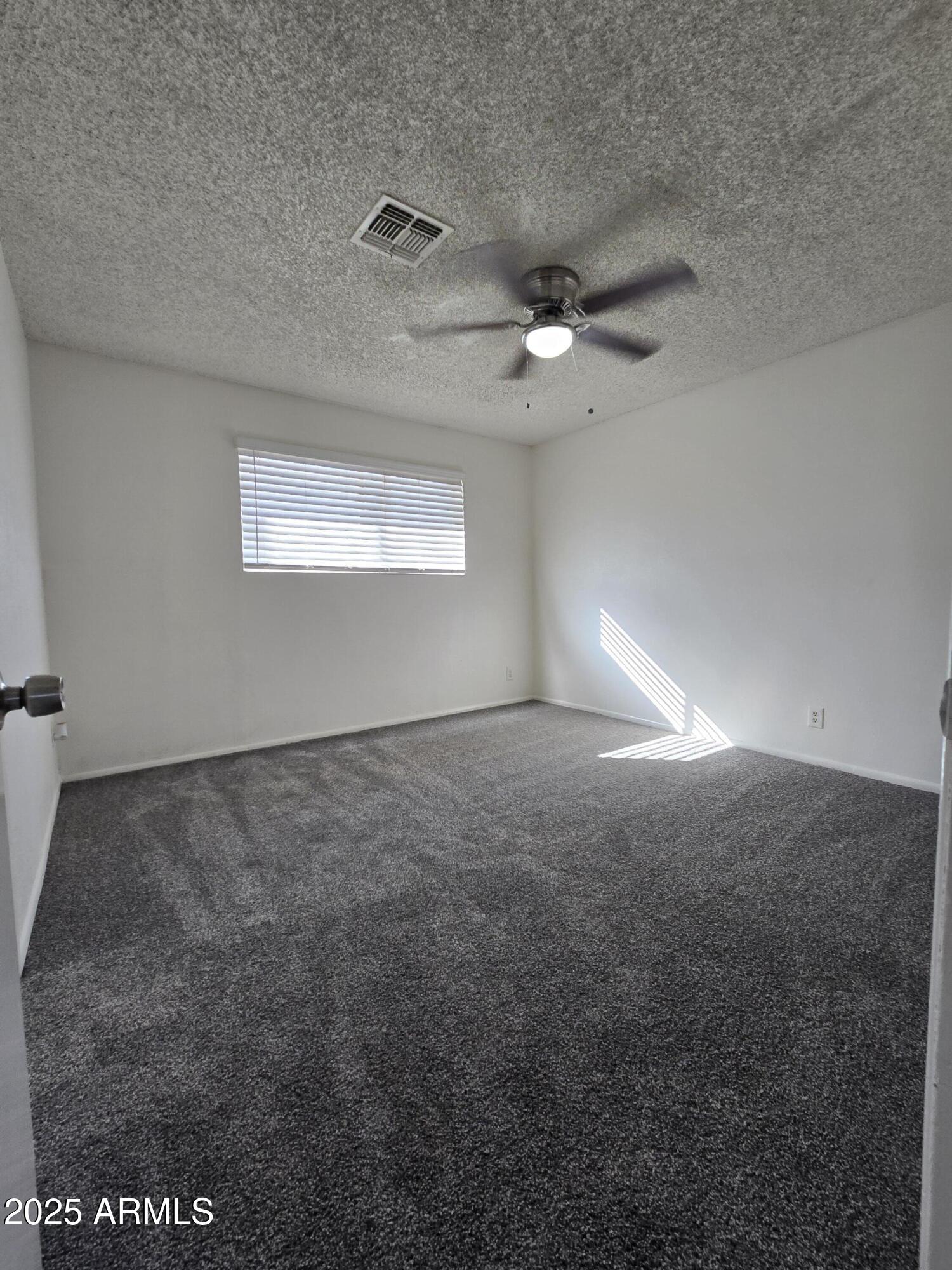 2211 West Pecan Road Phoenix, AZ 85041 - Photo 16 of 21 an empty room with a empty space and a ceiling fan