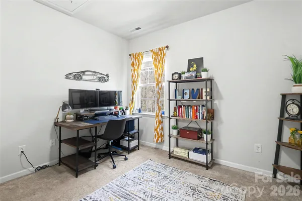 a view of a workspace with furniture and a window