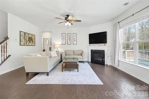 a living room with furniture a flat screen tv and a fireplace