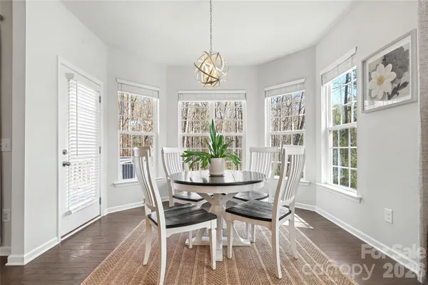 a dining room with furniture a chandelier and wooden floor